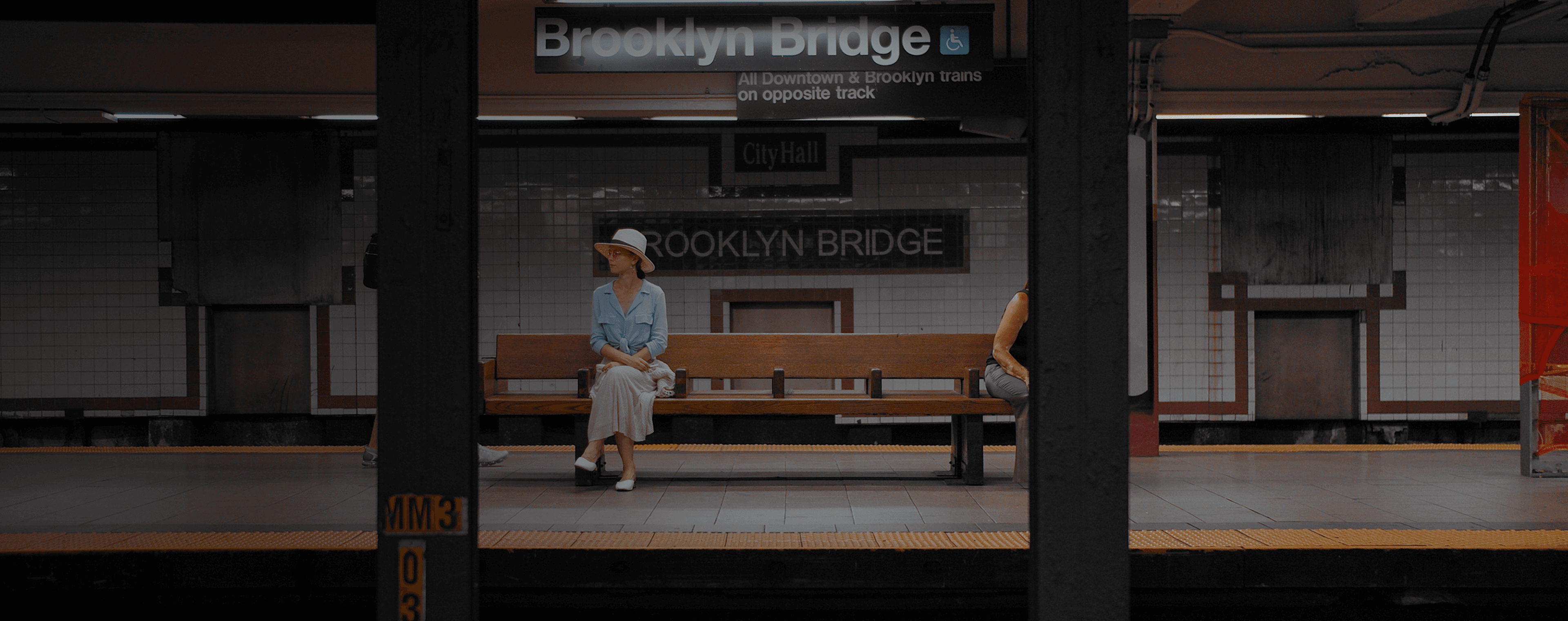 Una mujer se sienta en un banco en una estación de metro.