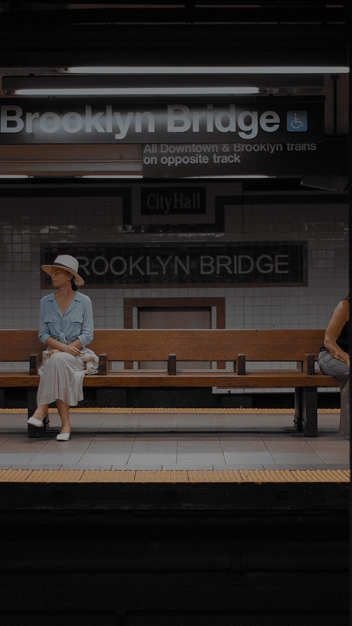 Una mujer se sienta en un banco en una estación de metro.